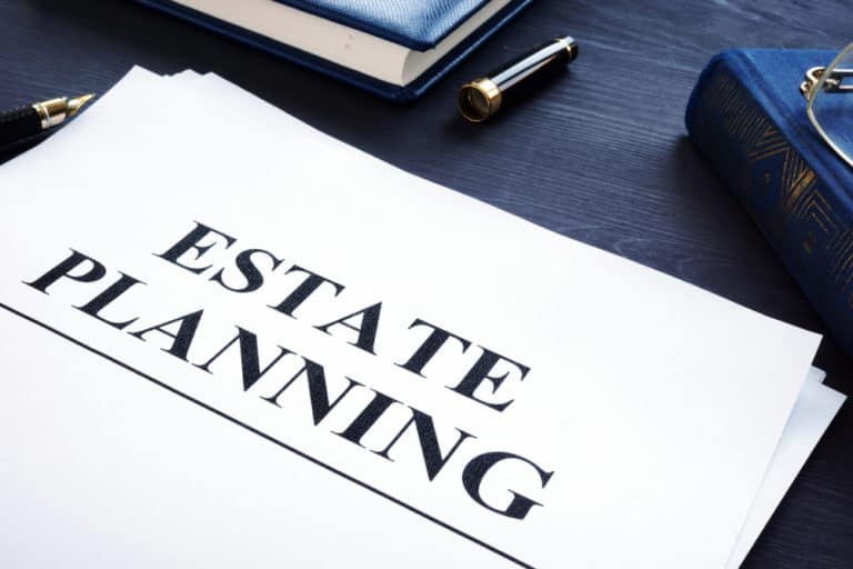 Estate planning documents sitting on a desk next to an uncapped pen