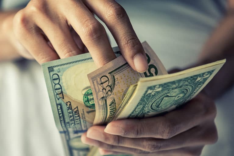 A person counting American currency